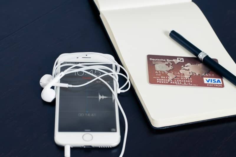 celular e cartão de banco sobre a mesa de uma pessoa que trabalhar em casa com vendas pela internet.