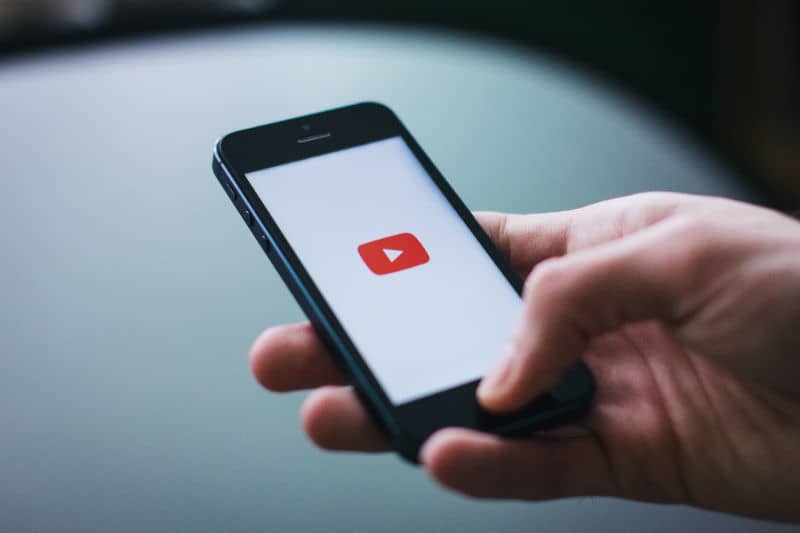 Pessoa usando o YouTube em um smartphone para ganhar dinheiro com a criação de conteúdo.