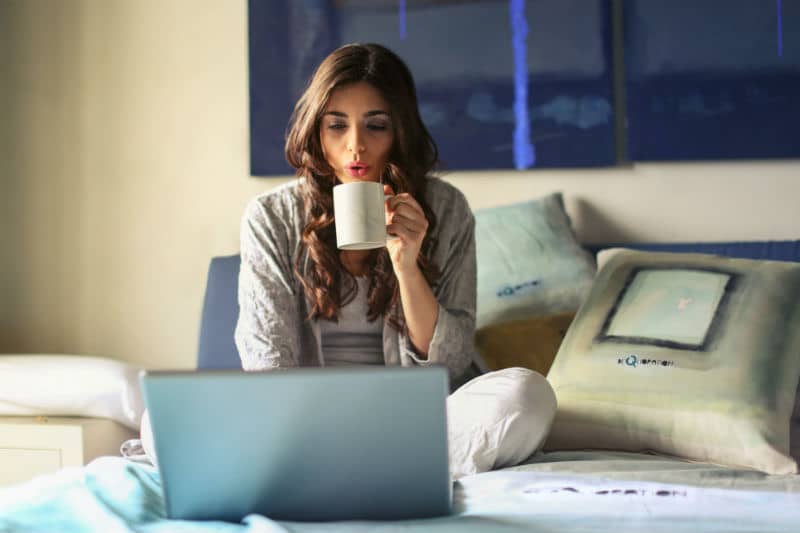 Uma imagem contendo pessoa, interior, laptop, mulher. Trabalhando em casa pelo computador