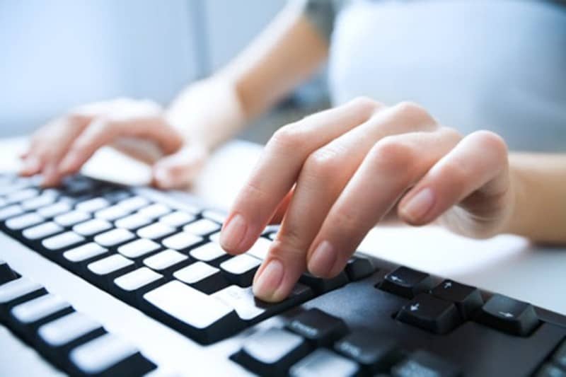 Mão em teclado de computador, programar horário de anúncio