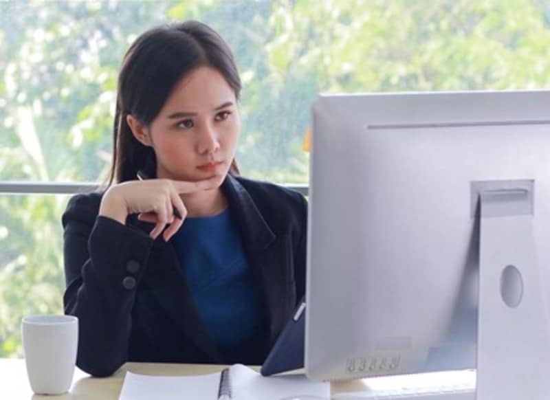 Mulher posando para foto em frente a computador, estudando marketing digital, negócios digitais